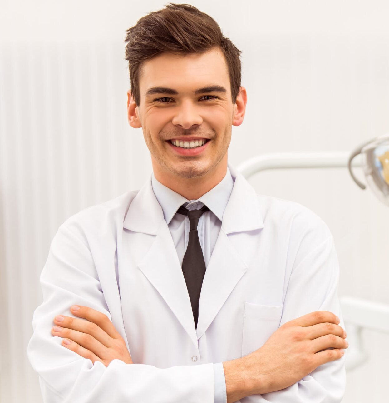 Portrait of a dentist. Young man at his workplace in the dental clinic